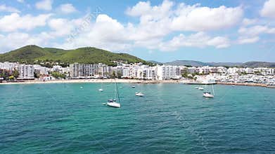 Aerial footage of the beautiful island of Ibiza, Spain in the Balearic islands showing the beach and hotels and boats by the