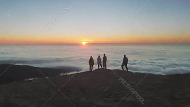 Aerial flight around group of peoples at sunrise