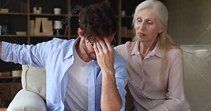 Aged mom listen to stressed adult son caress comfort support