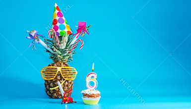 Creative congratulations on six years for a child. Pineapple with glasses in festive decorations. copy space. 6 year old birthday.
