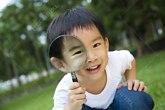 Curious boy with magnifier