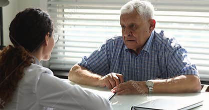 Older patient signing health insurance agreement in clinic