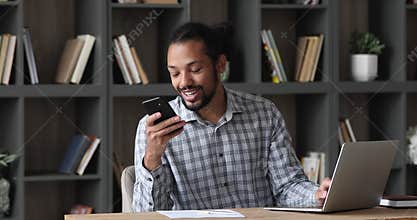 African businessman sit at desk answer the call use speakerphone