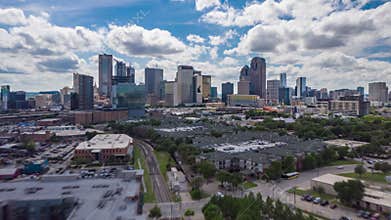 Drone low flight over residential area towards group of modern tall skyscrapers. Elevated hyper lapse footage of Dallas