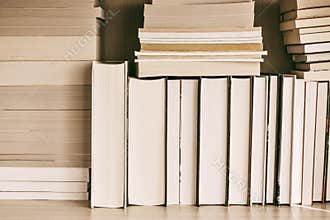 Hardback books on wooden shelf on the deck table, no labels, blank spine. Back to school. Education background