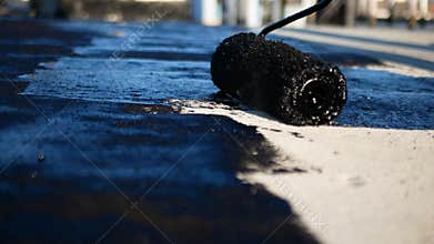 Flat roof waterproofing preparation using mastic primer close up by professionals