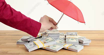 Banker holding an umbrella to keep money safe