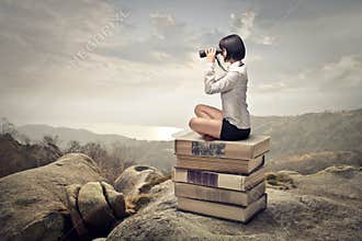 Woman sitting on a pile of books