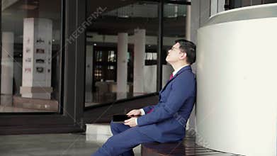 Professional young asian businessman in suit using tablet while sitting in modern office.