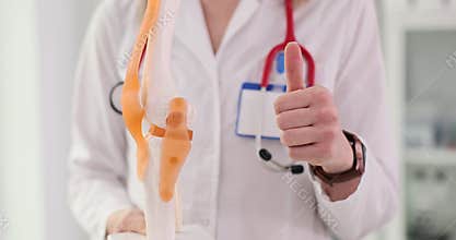 Doctor explains anatomy of knee and shows thumbs up