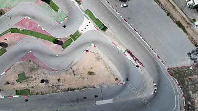Drone shooting, people in helmets ride kart cars on a special track.