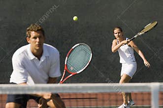 Mixed Doubles Player Hitting Tennis Ball