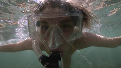 Underwater young woman snorkeling. A girl in a diving mask dives underwater. Travel lifestyle, outdoor water sports