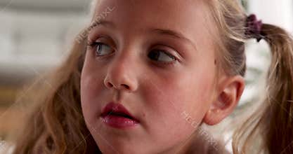 Attentive little girl looks to side observing surroundings