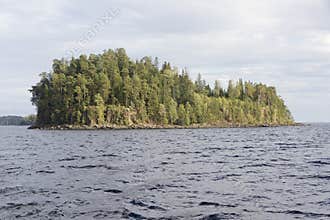 A small stone island on Lake Ladoga covered with pine woods