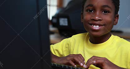 Little boy smiling at camera during computer class