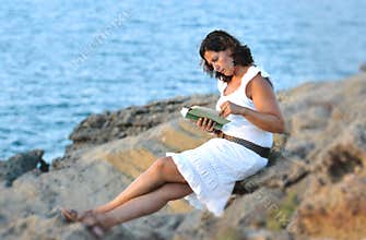 Attractive 40s mature woman reading and looking at horizon pensive