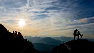 Girl and dog on top of the mountain