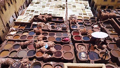 Workers dying leathers in traditional way in Chouara Tannery, Fez, Morocco