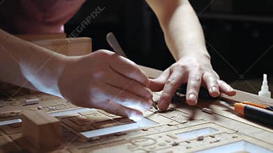 Hands of Professional Man Constructing Architecture Model of Urban City Building