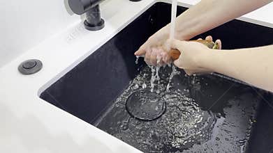 Wash vegetable process. Hand cleaning fresh carrot under faucet water