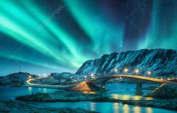 Bridge and northern lights over snowy mountains. Lofoten islands