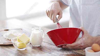 Close up of male hand whisking something in a bowl