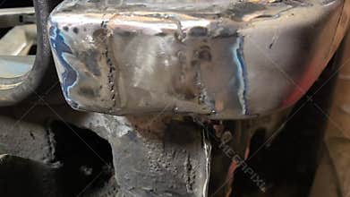 Welding on car body repair at workshop in daylight with tools and materials visible