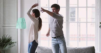Overjoyed young just married couple dancing to energetic music