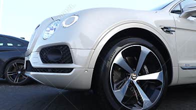 New Bentley Benteyga driving away from car showroom parking
