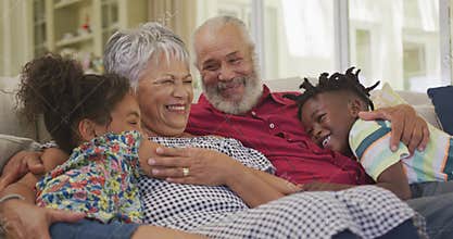 Grandparents embracing their grandchildren at home