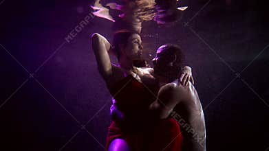 Black man is embracing his charming girlfriend underwater, lovers inside deep