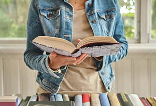 Woman hands holding open book in bookshop