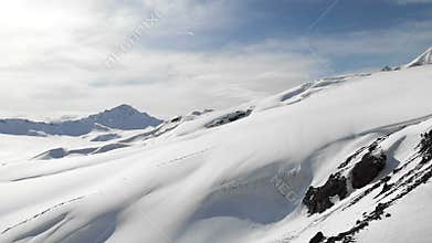 Aerial view of a winter mountain landscape. The snow-covered rocky slopes of the resort of the southern Elbrus region