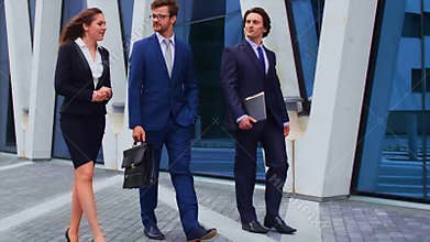 Confident businesspersons talking in front of modern office building. Businessmen and businesswoman have business