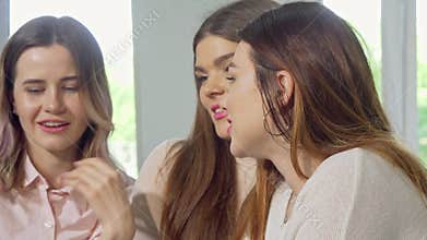Female college student smiling to the camera, while studying with her friends