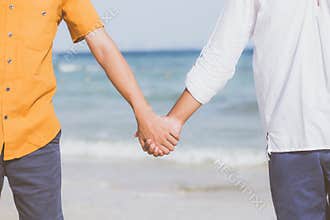Closeup asian gay couple holding hands together on the beach with relax and leisure in summer