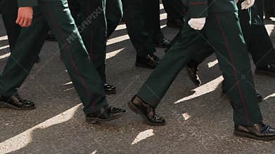 Soldier of military army walking in boots closeup in the parade of city square.