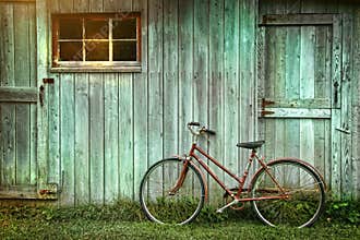 Bicycle leaning against grungy barn