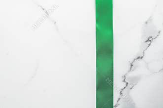 Green silk ribbon and bow on marble background, St Patricks day present or Christmas glamour gift decor for luxury digital brand,