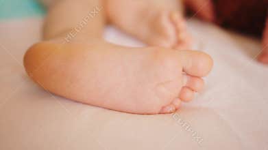 Baby Foot Lying on the Sheet Indoors
