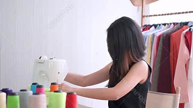 Young fashion designer sewing new collection in clothing studio