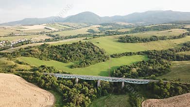 Summer landscape with fields, meadows and railroad bridge