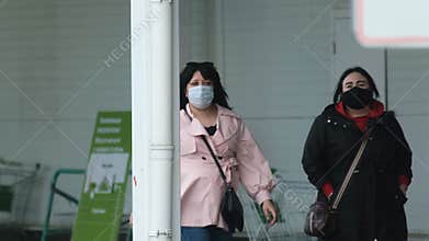 Masked women buyer walk in store street corona virus. People protected covid-19.