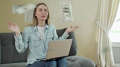 Successful young woman using laptop building online business making money dollar bills cash falling down. Dollars are