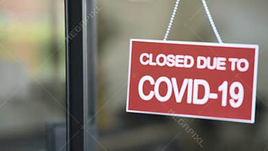 Red closed sign due to Covid-19 on shop window