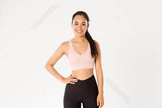 Sport, wellbeing and active lifestyle concept. Cheerful smiling asian girl promote you logo gym, special discount for