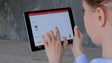 Woman using tablet with augmented reality app and placing 3d furniture in room