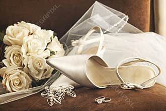 Wedding shoes with bouquet of white roses and ring