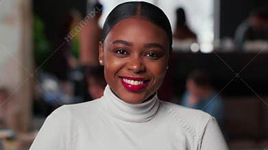 Portrait of happy young beautiful 20s gen-z black business woman with red lips smiling at camera at light trendy office.